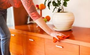 mulher limpando um rack de madeira