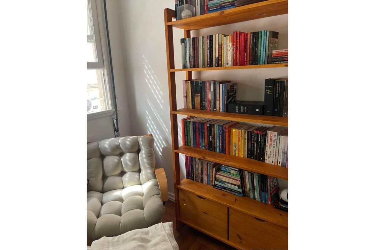 estante de madeira perto de uma poltrona