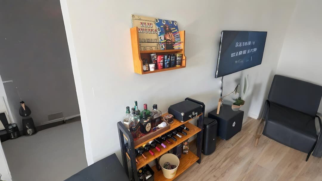 sala de estar com prateleira suspensa e adega com vinhos e outras bebidas