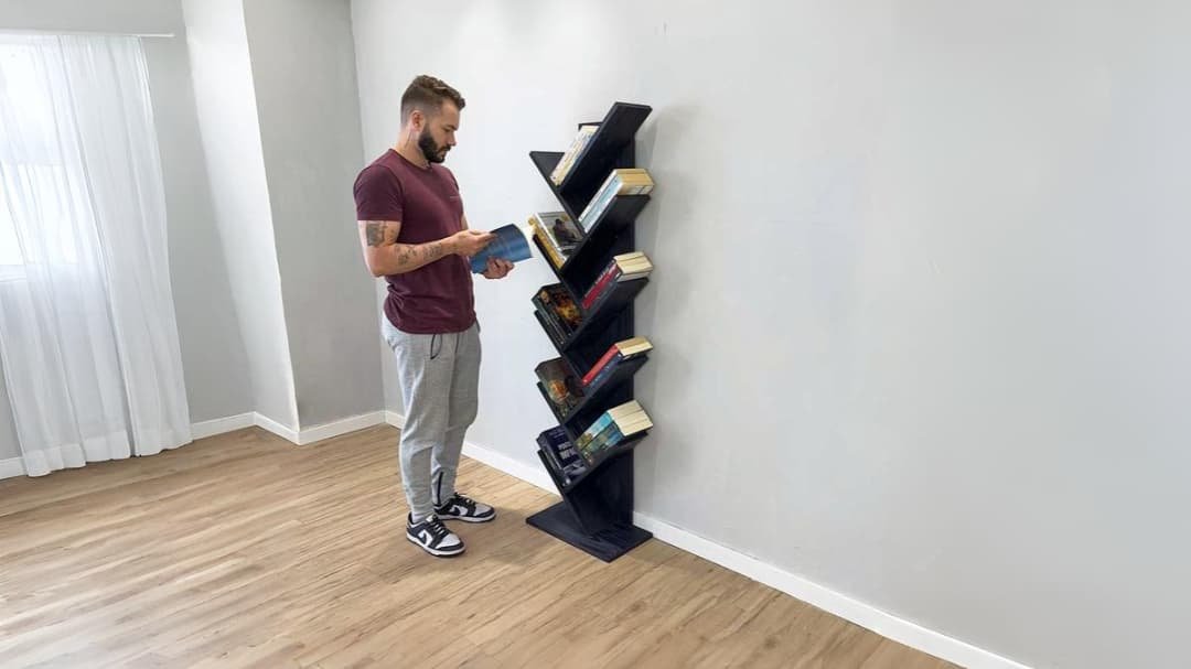 homem vendo livros em estante de madeira