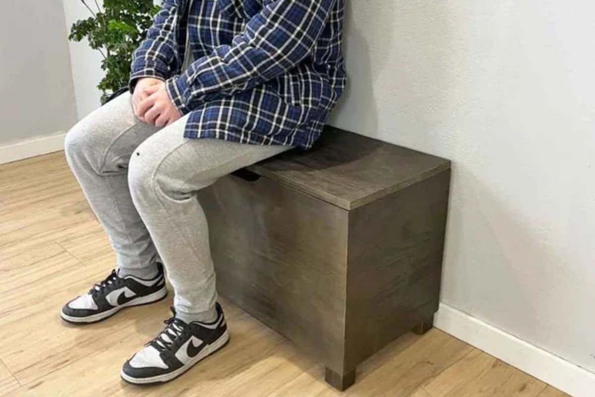homem sentado em banco bau